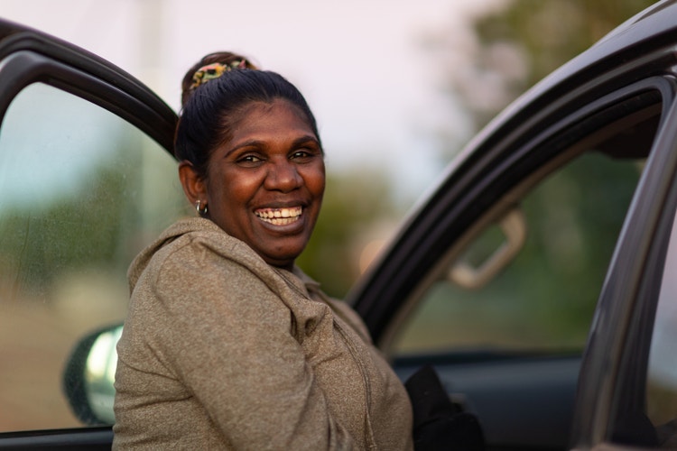 Smiling woman stepping into a car