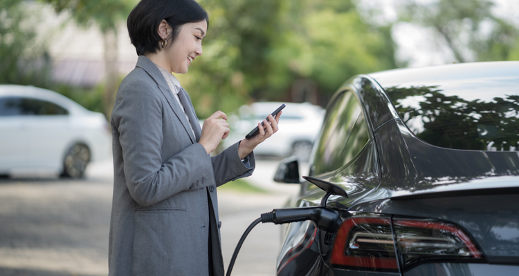 women on phone standing next to car